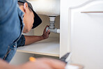 Engineering, plumbing and man fixing pipes by a sink for repairs or maintenance at a house. Professional, career and male plumber or contractor working on filter improvement or installation at a home