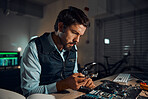 Man, circuit and it repair workshop in night for maintenance, computer tech or industry with focus. Technician, motherboard and information technology in dark with electronics, engineering and tools