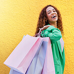 Portrait, shopping bag and happy black woman with wealth, success or promotion sale isolated on wall background. Retail, fashion and excited, young funky model or customer person for discount clothes