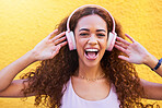 Music, freedom and portrait with a black woman listening to the radio outdoor on a yellow wall background. Headphones, energy and face with an attractive young female streaming audio sound for fun