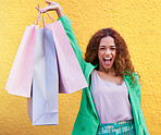 Shopping bag, portrait and black woman winning, success and promotion sale isolated on wall background. Retail, fashion and excited, winner and funky model, person or customer for clothes celebration