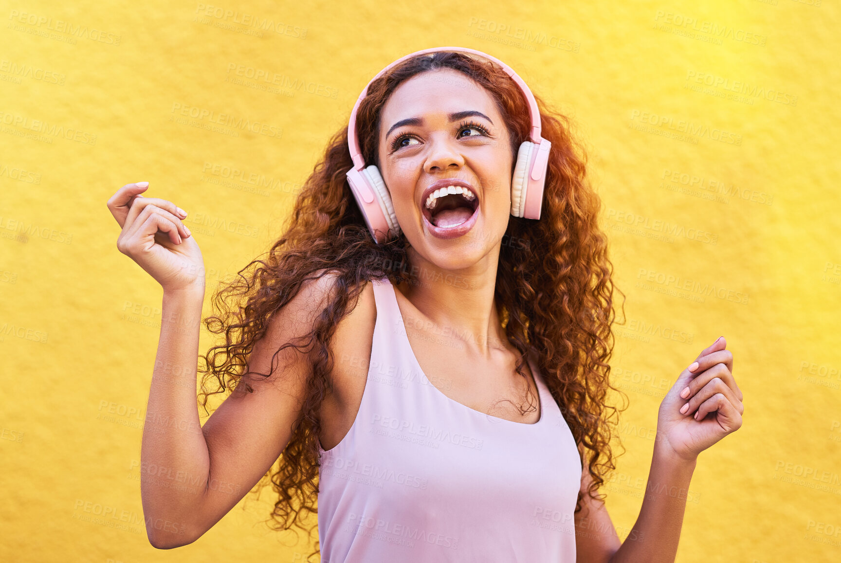 Buy stock photo Music, idea and dance with a black woman listening to the radio outdoor on a yellow wall background. Headphones, energy and face with an attractive young female streaming audio sound for fun