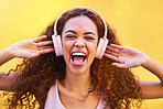 Music, face and shouting with a black woman listening to the radio outdoor on a yellow wall background. Headphones, energy and face with an attractive young female streaming audio sound for fun