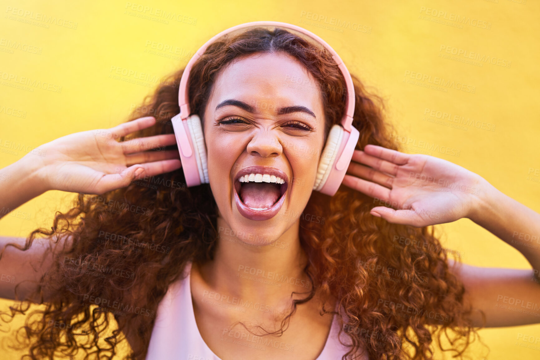 Buy stock photo Music, face and shouting with a black woman listening to the radio outdoor on a yellow wall background. Headphones, energy and face with an attractive young female streaming audio sound for fun