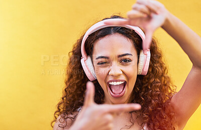 Buy stock photo Hands, frame and portrait of woman with headphones on yellow background for profile picture. Face, female and finger framing with music for perspective, selfie and vision of happiness, smile and tech