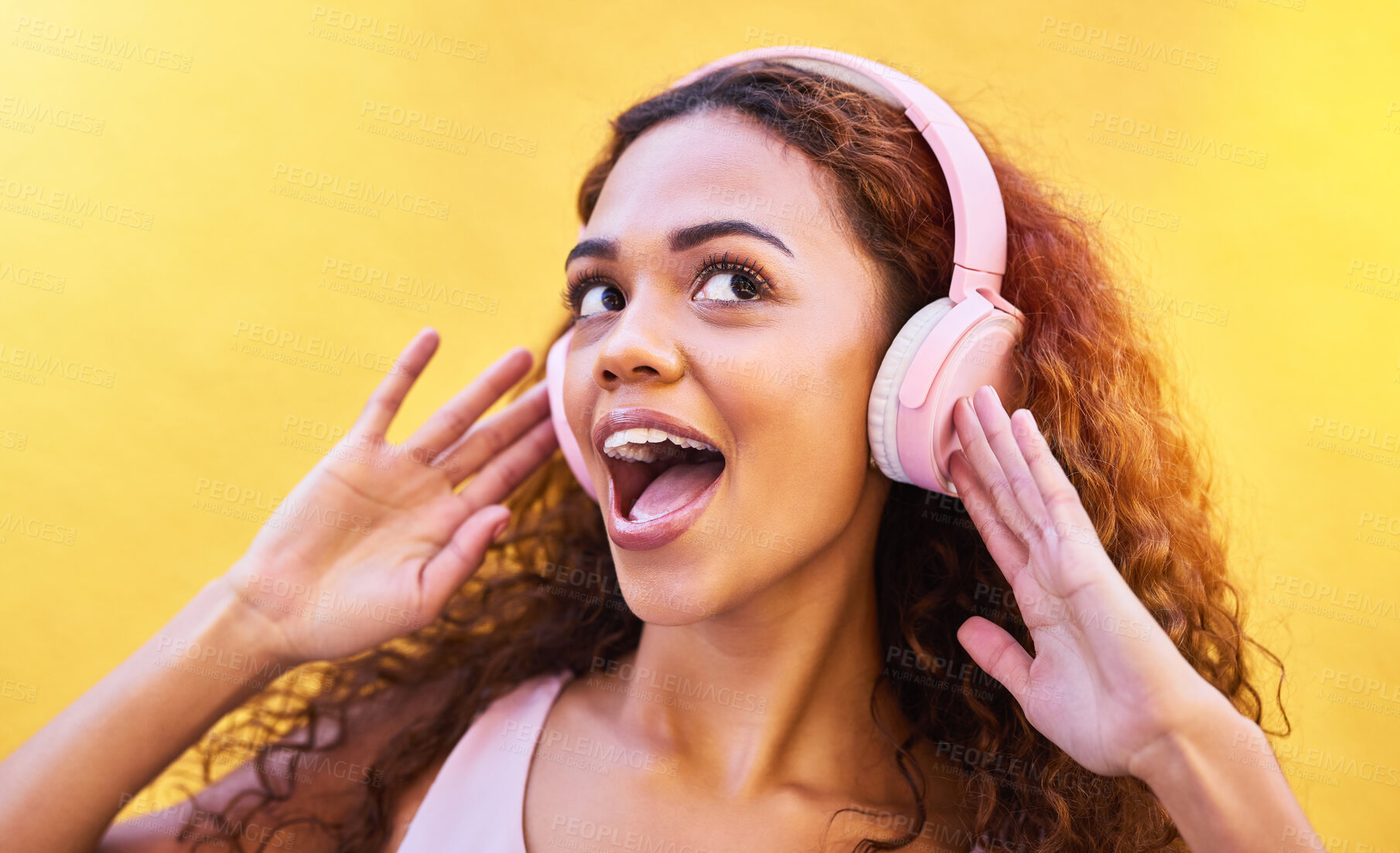Buy stock photo Music, freedom and wow with a black woman listening to the radio outdoor on a yellow wall background. Headphones, energy and face with an attractive young female streaming audio sound for fun