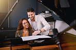 Musicians, piano and people writing music in a creative or recording studio with a song book. Art, creativity and couple in production of album or sound track together with a musical instrument.