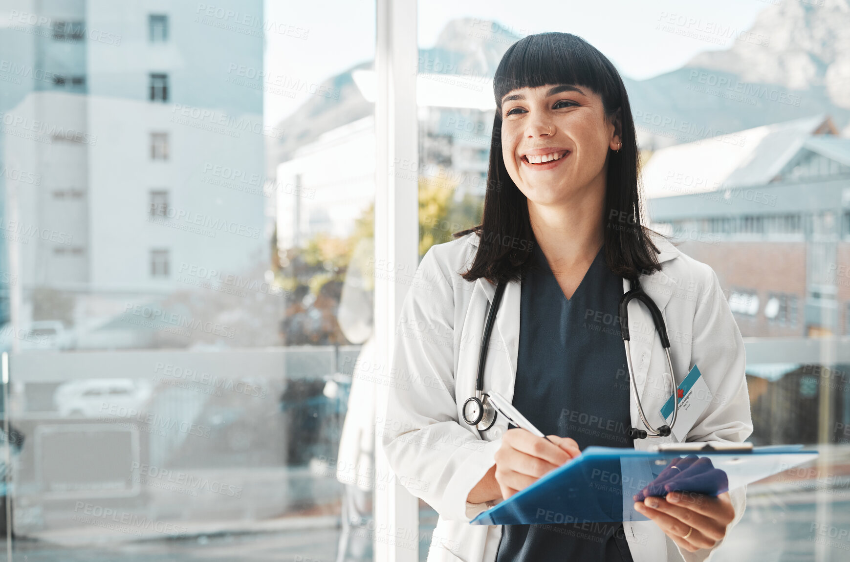 Buy stock photo Woman, doctor and smile writing on clipboard by window for healthcare planning, strategy or notes. Happy female medical expert smiling with paperwork, prescription or medicare details at hospital