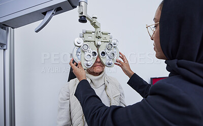 Buy stock photo Eye exam, optometry consultation and woman test for medical, healthcare and vision with muslim expert. Eyes check or consulting of senior person and professional optometrist with phoropter machine