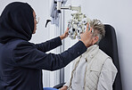 Eye exam, healthcare and senior woman with optometrist in clinic for testing eyes, eyesight and optical assessment. Optometry, vision and Muslim optician with patient, phoropter and medical machine