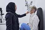 Eye exam, vision and woman with Muslim optometrist in clinic for test, eyesight and optical assessment. Optometry, healthcare and female optician with elderly patient, phoropter and medical tools