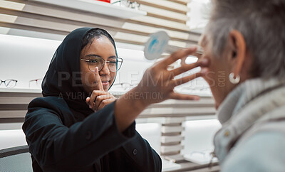 Buy stock photo Optometry, vision and eye test with an islamic woman optician working to diagnose a customer. Doctor, optometrist and eyecare with a muslim female testing a client for prescription lenses in a clinic