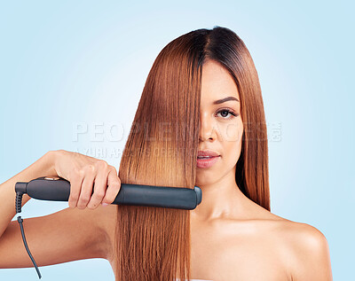 Buy stock photo Face portrait, beauty and woman with hair straightener in studio isolated on a blue background. Haircare, product and female model with flat iron for salon treatment, hairstyle aesthetic or balayage.
