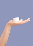 Hands, skincare and cream container in studio isolated on a purple background for hydration. Cosmetics, dermatology and woman or female model with lotion, creme or moisturizer for beauty aesthetics.