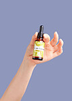 Skincare treatment, model hands and essential oil serum with product bottle for dermatology. Studio beauty, wellness and self care with hyaluronic acid for collagen production with purple background