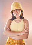 Asian woman, fashion and confident with gen z and portrait, yellow aesthetic and edgy on studio background. Streetwear, beauty and cosmetics with style, female and empowerment with arms crossed