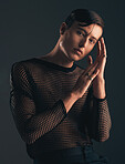 Gender neutral, face and fashion, portrait on dark background and trendy, edgy with hands. Creative, gen z and beauty, sexy and cosmetics with serious non binary person in designer clothes