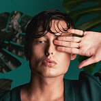 Gen z, man and portrait of a male model with hand palm and fashion aesthetic. Isolated, blue background and studio of a young person with Monstera plants for organic skincare and eco friendly style