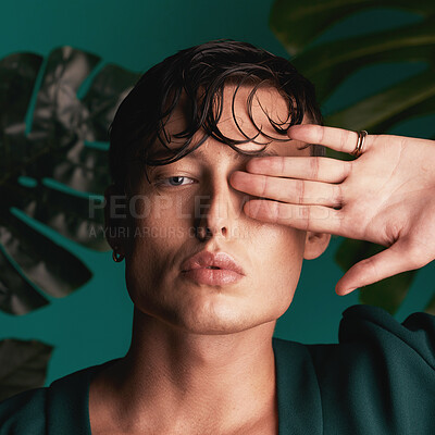 Buy stock photo Gen z, man and portrait of a male model with hand beauty and fashion face. Isolated, green background and studio of a young person with Monstera plants for organic skincare and eco friendly style