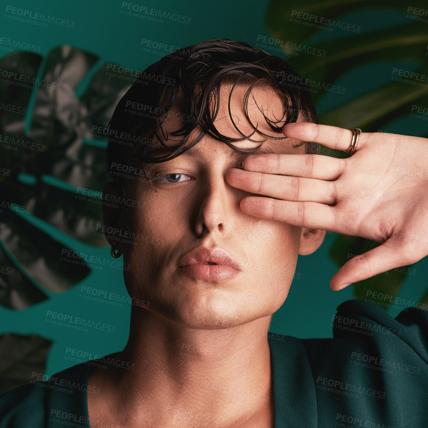 Buy stock photo Gen z, man and portrait of a male model with hand beauty and fashion face. Isolated, green background and studio of a young person with Monstera plants for organic skincare and eco friendly style