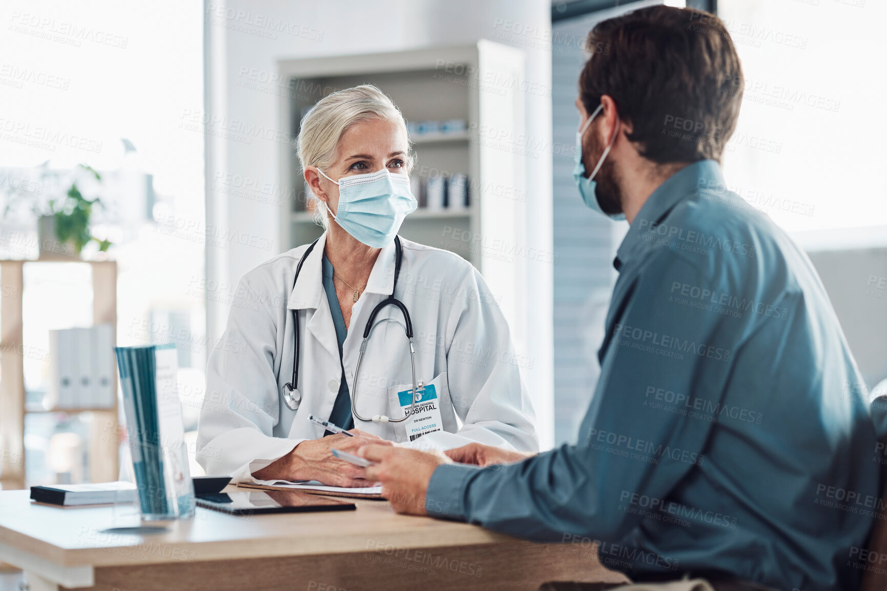 Buy stock photo Consultation, covid and doctor with a man for healthcare, medical attention and service. Medicine, support and consultant with a face mask for virus while talking to a patient about health results