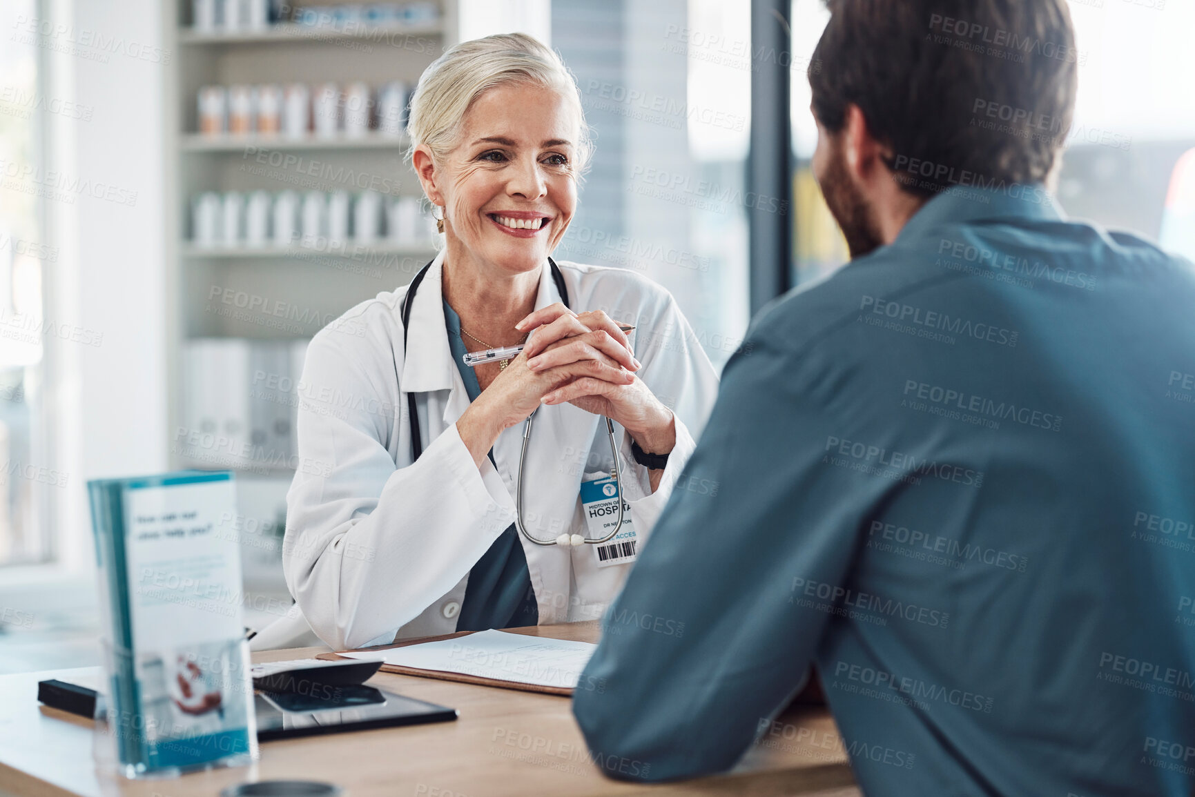 Buy stock photo Consultation, doctor and patient talking with woman in hospital for doctors appointment. Healthcare, wellness and man consulting happy senior medical professional for health advice or help in clinic.