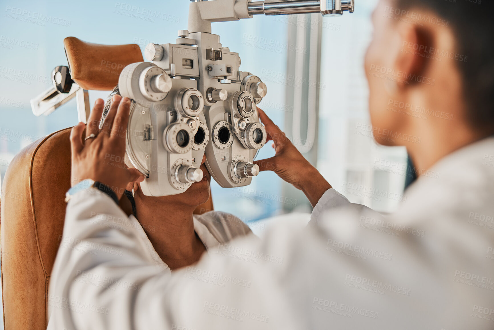 Buy stock photo Senior optometry woman, eye exam patient and medical goal in hospital, consultation room and office with help. Elderly optician, eyesight test and phoropter for wellness, health and vision analysis