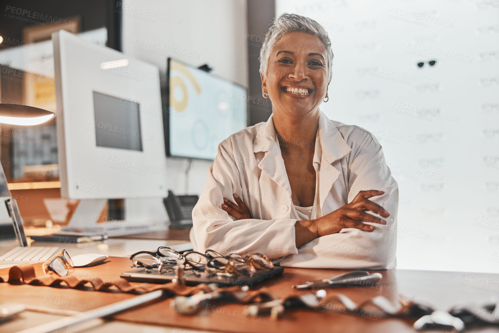 Buy stock photo Senior optometrist woman, portrait and office with glasses, smile or frame design planning at desk. Happy optician, spectacle designer and excited face in workplace for pride, small business and goal