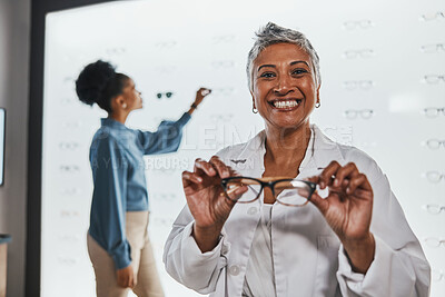 Buy stock photo Smile, mature woman holding glasses and shopping for frames and prescription lens at designer eyewear store. Vision, eyesight and healthcare, happy customer with new frame in hands at spectacle shop.