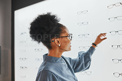 Buy stock photo Vision, optometry and black woman shopping for glasses, spectacles or frames at optical store. Eye care, ophthalmology and happy female customer with choice or decision for retail lenses or eyewear.