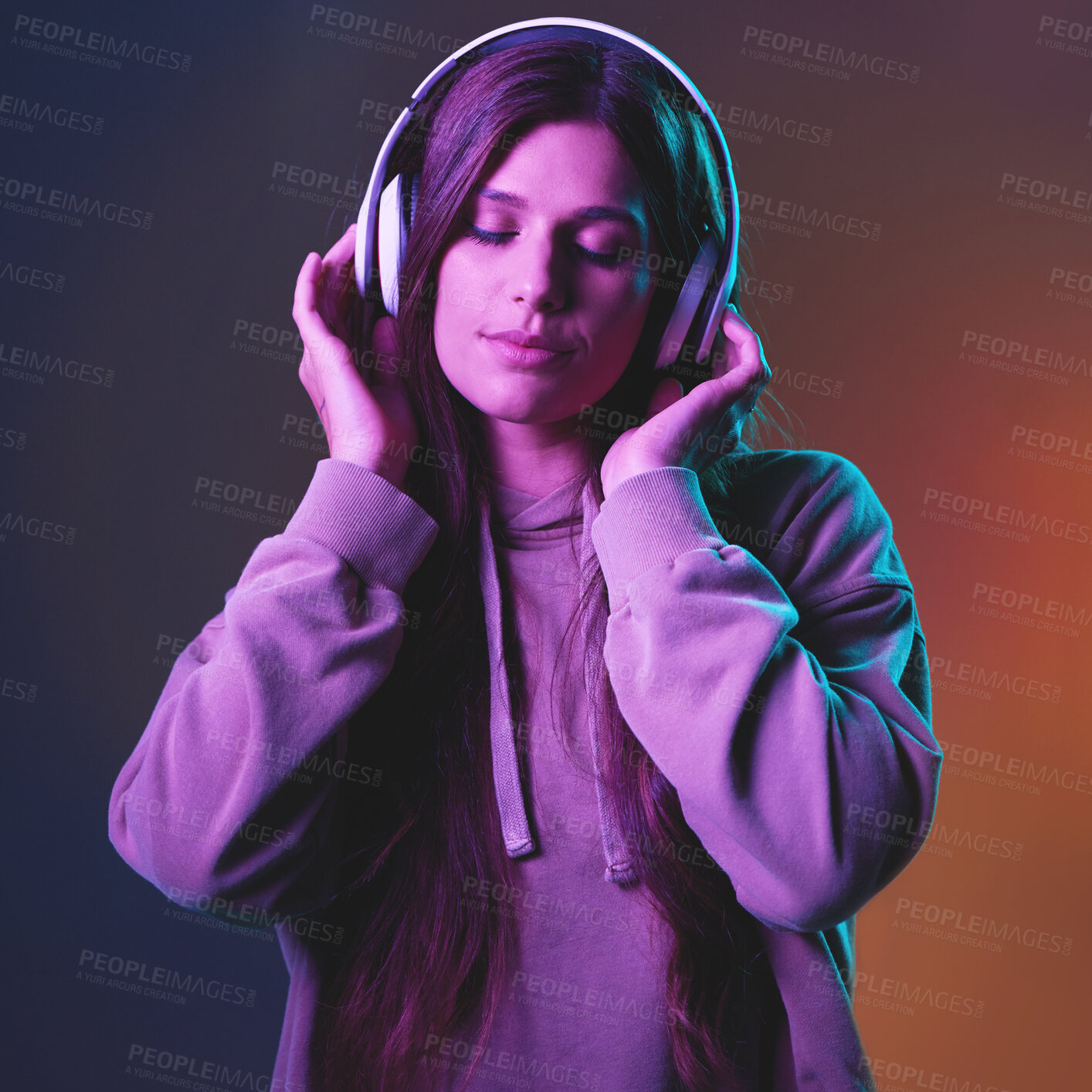 Buy stock photo Music, neon and gen z with a woman in studio listening to the radio for freedom on a wall background. Cyberpunk, headphones and streaming audio with an attractive young female hearing her best song