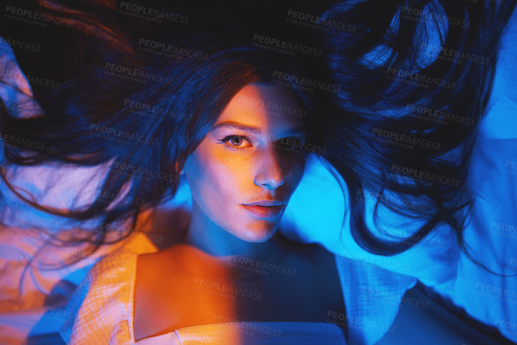 Buy stock photo Portrait, vaporwave lights and young woman face in bedroom with creative disco lighting. Makeup, beauty and model resting and feeling relax and calm on a bed pillow with cyberpunk aesthetic 