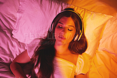 Buy stock photo Gen z, headphones and woman sleeping with creative vaporwave lighting in a bedroom bed. Dreaming, music listening and web audio streaming of a female model resting eyes with makeup on a pillow