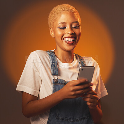 Buy stock photo Black woman, phone and smile for social media, communication or chatting against a studio background. Happy African American female smiling or laughing for funny joke, meme or post on smartphone