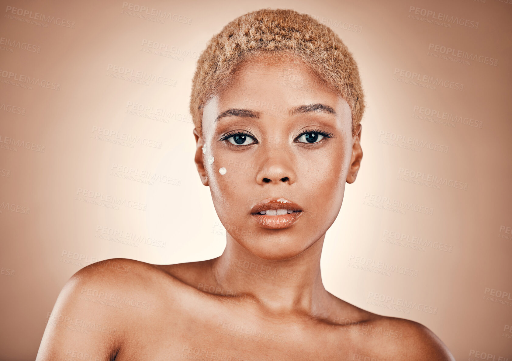 Buy stock photo Beauty, skincare and portrait of black woman with cream on face in studio with mockup, luxury cosmetics and glowing skin. Natural makeup, spa facial and golden aesthetic on model on brown background.