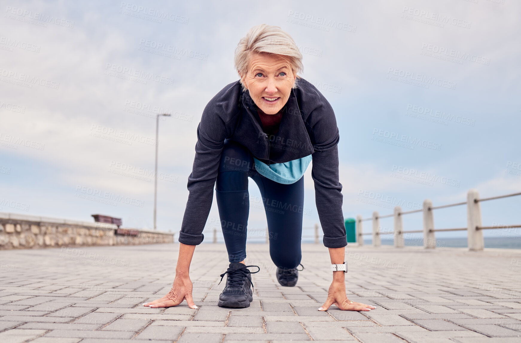 Buy stock photo Senior woman, starting position and running outdoor at beach promenade, runner exercise or sky mockup. Elderly lady ready to run, cardio and fitness training for mindset of sports, marathon or energy