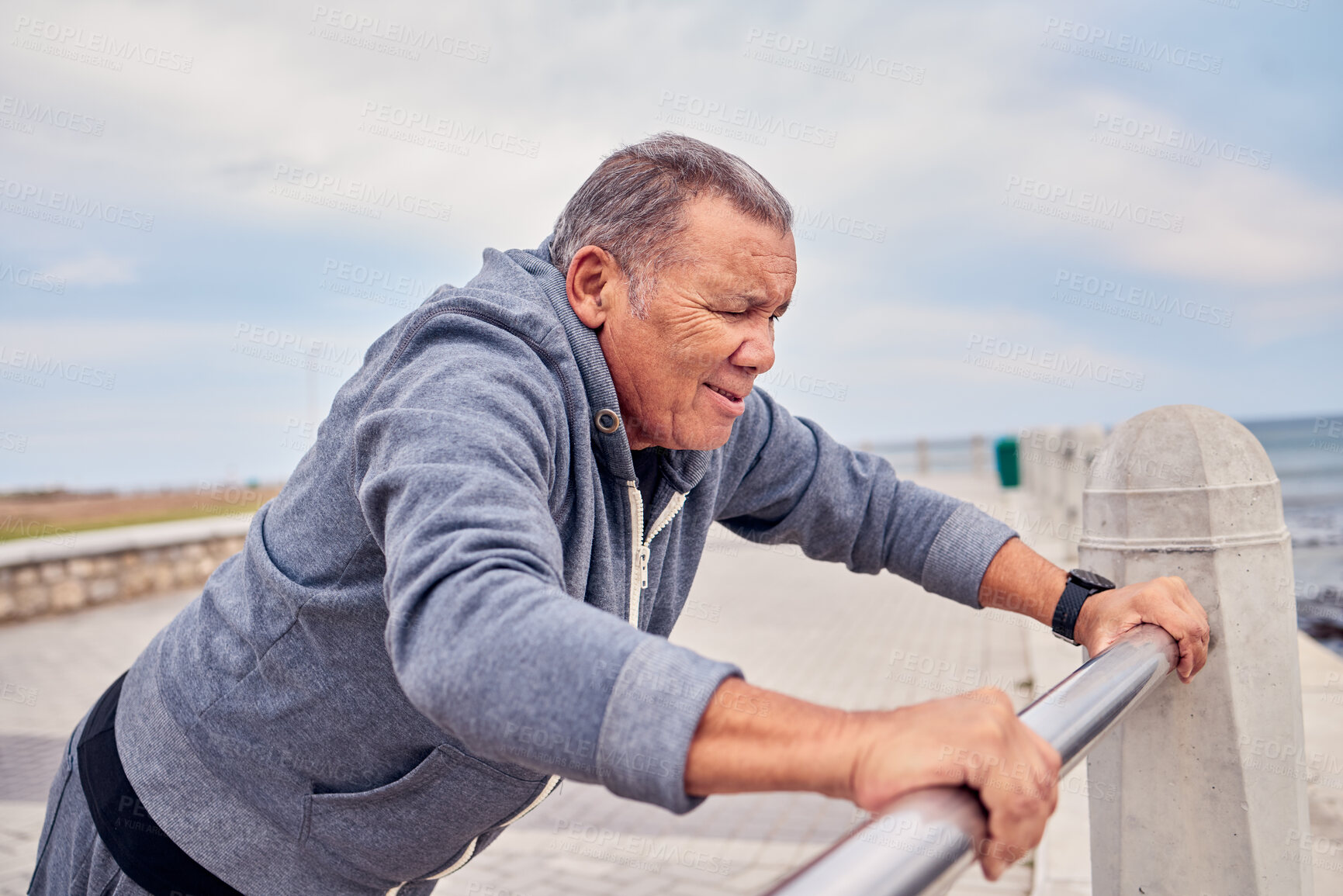 Buy stock photo Fitness, promenade and man doing a stretching exercise before running or training for race. Sports, athlete and senior male runner doing a body warm up by the beach for an outdoor cardio workout.