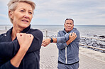 Stretching, fitness and senior couple by ocean for exercise, healthy body and wellness in retirement. Sports, nature and elderly man and woman ready for warm up, cardio workout and training outdoors