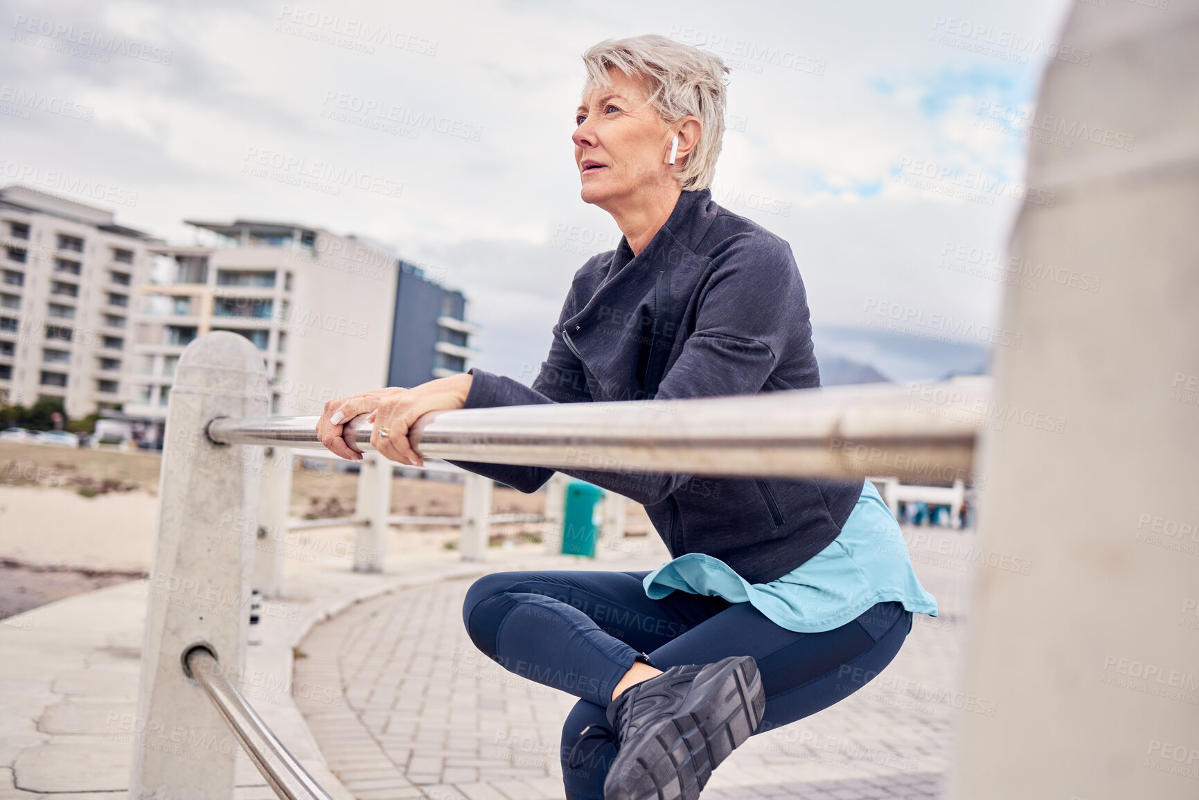 Buy stock photo Fitness, music and stretching with a senior woman getting redy for a cardio workout on the promenade. Exercise, warm up and running with a mature female athlete in preparation on an early morning jog