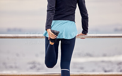 Buy stock photo Fitness, outdoor and woman stretching her legs before running or training by the promenade. Sports, wellness and female athlete runner doing a warm up exercise before a cardio workout by the beach.