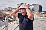 Senior man, smile and helmet at the beach with bicycle for weekend, trip or holiday travel in Cape Town. Happy elderly male biker or cyclist smiling for cycling, journey or break by the ocean coast