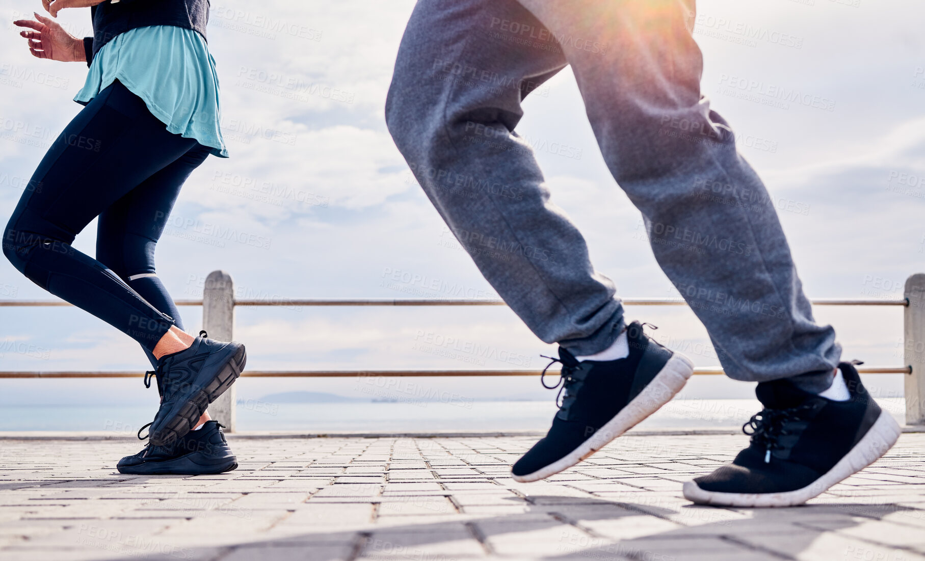 Buy stock photo Legs of people, fitness and running at promenade beach for energy, wellness and workout. Closeup man, woman and feet outdoor for cardio exercise at sea for marathon training, shoes and sports runners