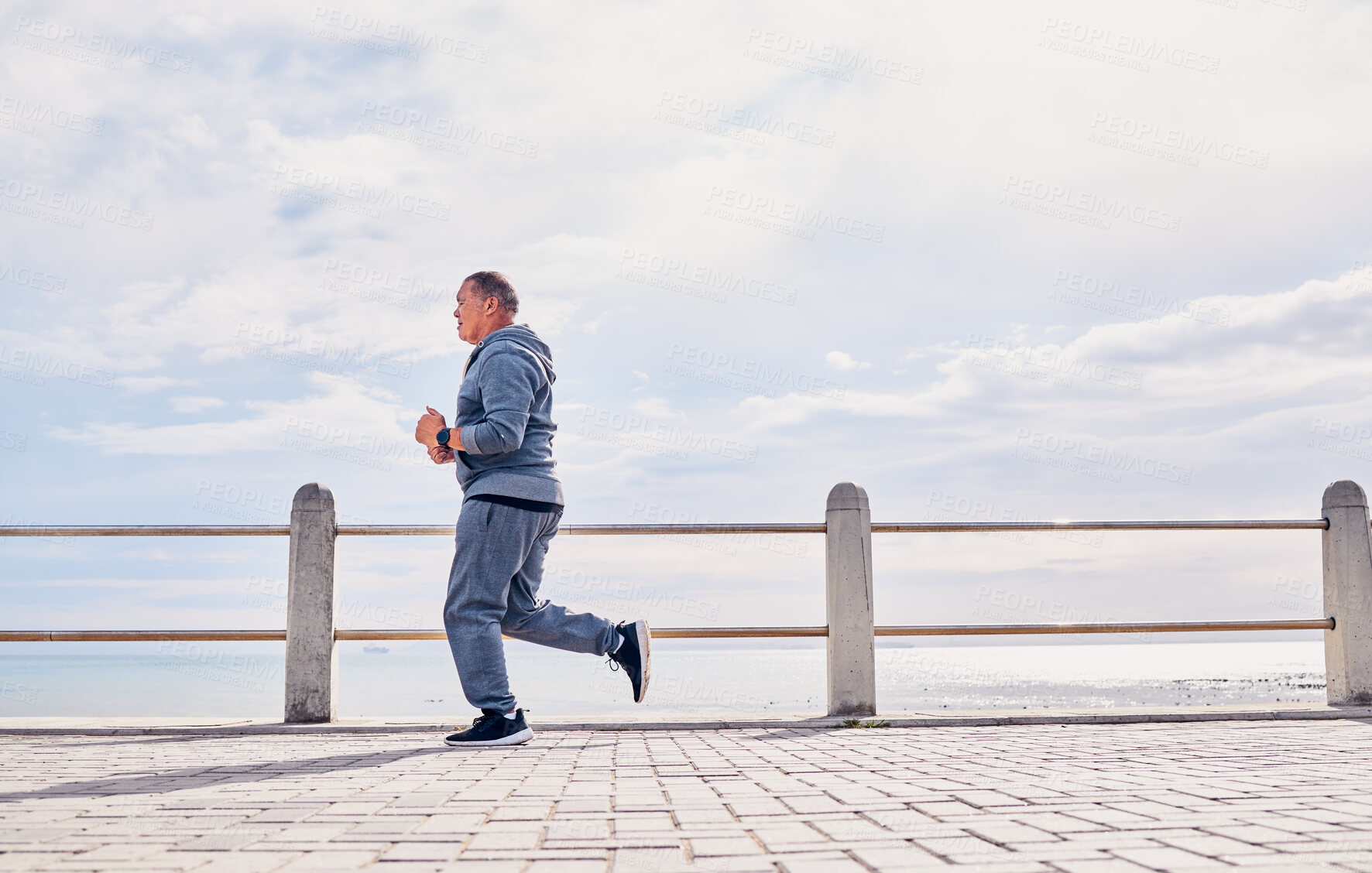 Buy stock photo Senior man, sports and running at beach promenade with sky mockup for energy, body wellness and cardio workout. Elderly male, exercise and runner at seaside for training, fitness and healthy marathon