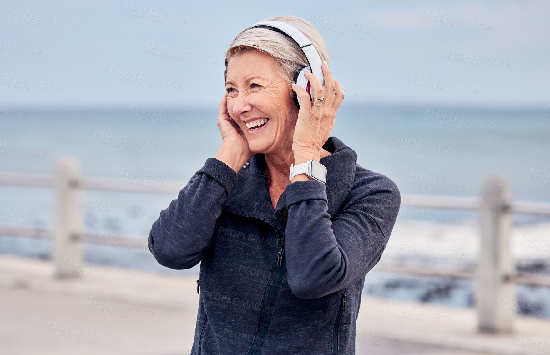 Buy stock photo Old woman at beach, headphones and listening to music with smile on face, happiness and freedom outdoor. Fitness, fresh air and technology, podcast or radio streaming with mature female in retirement