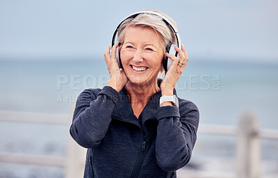 Buy stock photo Old woman at beach, headphones and listen to music with smile on face, happiness and freedom outdoor. Fitness, fresh air and technology, podcast or radio streaming with mature female in retirement