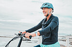 Senior woman, bike and smile in cycling by the beach for fun activity or travel in the city. Happy elderly woman smiling and enjoying cruise on bicycle for traveling, trip or fitness by ocean coast