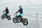 Couple, helmet or electrical bike by sea or ocean beach in bonding transport, clean energy or sustainability travel. Technology, electric or eco friendly bicycle for happy woman or mature cycling man