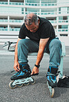 Roller skate, tie shoes and senior man in city for sports, adventure and fitness hobby outdoors. Exercise, weekend and elderly man with shoelaces ready for skating, urban travel activity and journey