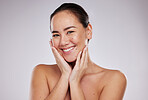 Skincare, hands on face and portrait of woman in studio for beauty, dermatology and skin cosmetics. Aesthetic asian model person smile for makeup glow and luxury facial self care on a grey background