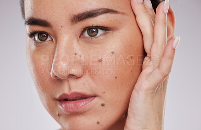 Buy stock photo Beauty, face and skincare of a woman in studio for makeup, dermatology and cosmetics for skin glow. Aesthetic asian model person with hand to show mole and facial self care for health and wellness